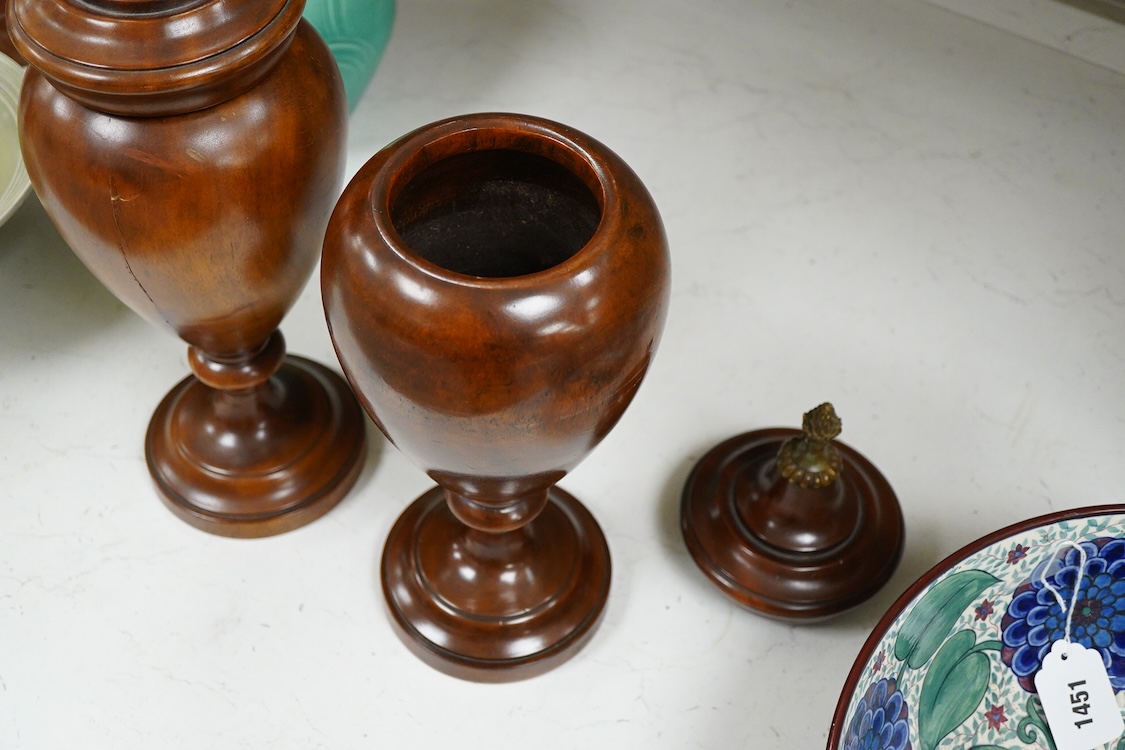 A pair of turned hardwood urns and covers, 42cm